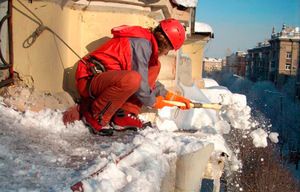 Чистка снега с крыши у одного из домов Дзержинского